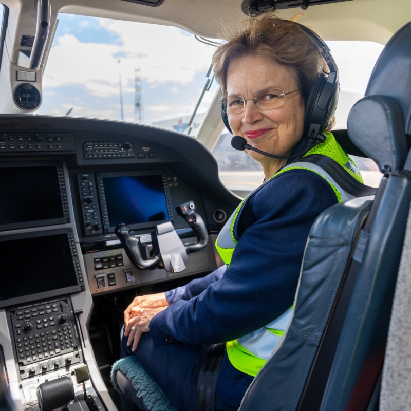 South Australian Governor Frances Adamson wearing a headset and sitting in a cockpit of a Royal Flying Doctor Service plane.